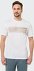 Mann in weißem T-Shirt mit Aufdruck und blauer Hose.