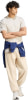 Mann in beige T-Shirt und Jogginghose mit blauer Sweatjacke um die Taille.