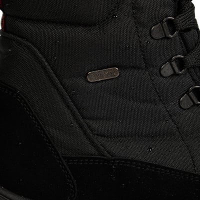 Detail eines Stiefels mit Aquamax-Logo und Metallösen für Schnürsenkel. Detail eines Stiefels mit Aquamax-Logo und Metallösen für Schnürsenkel.