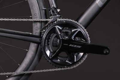 Detailaufnahme der Kurbel und Kette eines Fahrrads mit Shimano 105 Schriftzug. Detailaufnahme der Kurbel und Kette eines Fahrrads mit Shimano 105 Schriftzug.