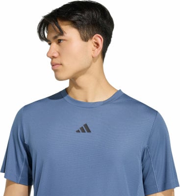 Ein Mann in einem blauen T-Shirt mit Adidas-Logo. Ein Mann in einem blauen T-Shirt mit Adidas-Logo.