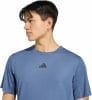 Ein Mann in einem blauen T-Shirt mit Adidas-Logo.