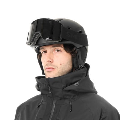 Ein Mann in einem schwarzen Skihelm und einer Jacke.