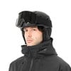 Ein Mann in einem schwarzen Skihelm und einer Jacke.