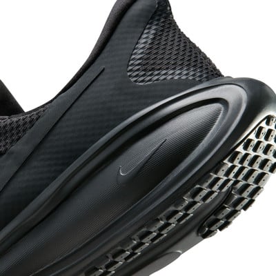 Detail černých běžeckých bot Nike s mřížkovanou podrážkou.