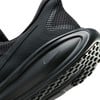 Detail černých běžeckých bot Nike s mřížkovanou podrážkou.