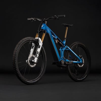 Blaues Mountain-E-Bike mit Federung und goldener Sattelstütze. Blaues Mountain-E-Bike mit Federung und goldener Sattelstütze.
