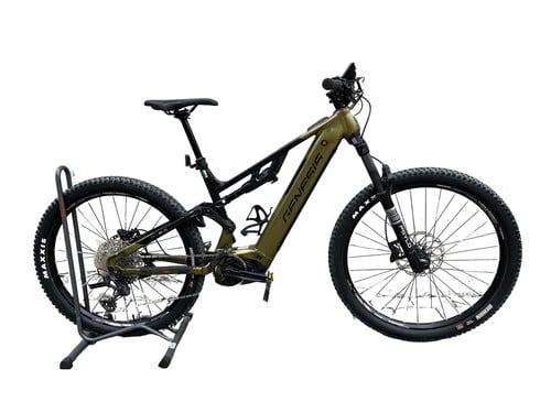 Grünes Genesis Mountain E-Bike auf Ständer, Detail des Vorderrads.