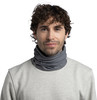 Ein Mann mit braunen lockigen Haaren trägt einen grauen Schlauchschal und einen Pullover.