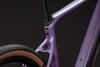 Detail des Rahmens eines violetten Gravelbikes mit zwei Schrauben und Reifen.