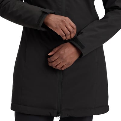 Eine Frau schließt den Klettverschluss am Ärmel einer schwarzen Jacke. Eine Frau schließt den Klettverschluss am Ärmel einer schwarzen Jacke.