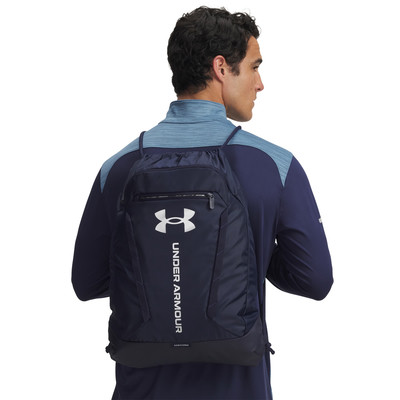 Egy férfi sötétkék Under Armour hátizsákkal a hátán. Egy férfi sötétkék Under Armour hátizsákkal a hátán.