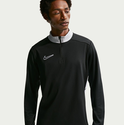 Ein Mann in einem schwarzen Langarmshirt mit grauem Kragen von Nike. Ein Mann in einem schwarzen Langarmshirt mit grauem Kragen von Nike.