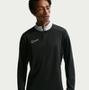 Ein Mann in einem schwarzen Langarmshirt mit grauem Kragen von Nike.
