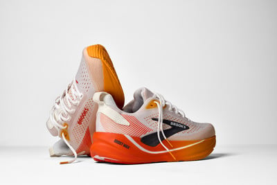 Zwei Brooks-Laufschuhe mit orange-weißer Sohle. Zwei Brooks-Laufschuhe mit orange-weißer Sohle.