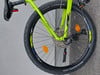 Detail des Hinterrads eines grünen Mountainbikes mit Kassette und Schaltwerk.