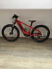 Ein orangefarbenes KTM-Mountainbike mit dicken Reifen auf Holzboden.