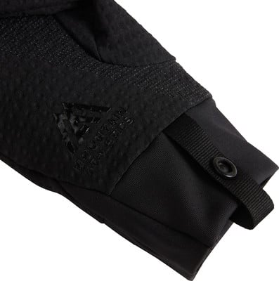 Detail eines schwarzen Jackenärmels mit Logo und Druckknopfverschluss. Detail eines schwarzen Jackenärmels mit Logo und Druckknopfverschluss.
