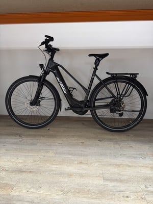 Ein schwarzes KTM E-Bike mit Gepäckträger und Licht steht auf dem Boden. Ein schwarzes KTM E-Bike mit Gepäckträger und Licht steht auf dem Boden.