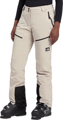 Damen-Skihose in Beige mit schwarzen Akzenten und Skischuhen. Damen-Skihose in Beige mit schwarzen Akzenten und Skischuhen.
