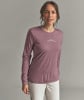 Frau in einem rosafarbenen Langarmshirt mit Bergmotiv auf der Brust.