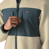 Detail einer Patagonia-Jacke mit Logo und Reißverschluss, beige und dunkelblau.