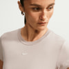 Detail eines Damen-T-Shirts von Nike mit silbernem Logo auf hellem Hintergrund.