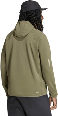 Mann in olivgrüner Kapuzenjacke und schwarzer Kappe, Rückansicht.