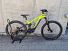 Grünes E-Mountainbike auf einem Ständer vor einer Wand.