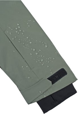Grüner Stoff mit Wassertropfen und schwarzem Klettverschluss.