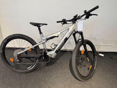 Silbernes Mountain-E-Bike mit Federung und Intersport-Logo. Silbernes Mountain-E-Bike mit Federung und Intersport-Logo.