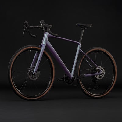Lila Gravelbike mit braunen Reifen vor schwarzem Hintergrund. Lila Gravelbike mit braunen Reifen vor schwarzem Hintergrund.