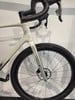 Nahaufnahme des Vorderteils eines weißen Gravelbikes mit Lenker und Rad.
