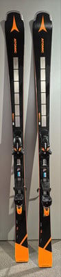 Atomic Redster Skier mit Bindung sind schwarz mit orangefarbenen Akzenten.