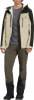 Ein Mann in einer beige Jacke mit dunkelgrünen Ärmeln und brauner Hose.