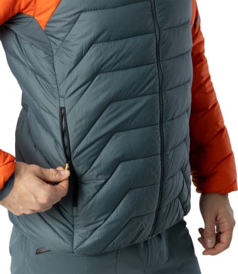 Detail einer Jacke mit orangefarbenen Ärmeln und grauer Steppweste. Detail einer Jacke mit orangefarbenen Ärmeln und grauer Steppweste.