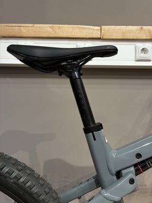 Ein Fahrradsattel mit verstellbarer Sattelstütze an einem grauen Rahmen. Ein Fahrradsattel mit verstellbarer Sattelstütze an einem grauen Rahmen.