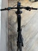 Draufsicht auf ein schwarzes E-Mountainbike mit Display am Lenker.