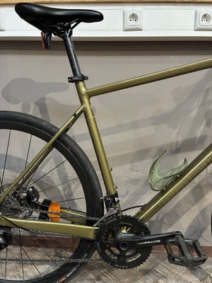 Ein goldenes Fahrrad mit schwarzen Pedalen und Sattel, an der Wand mit Steckdosen. Ein goldenes Fahrrad mit schwarzen Pedalen und Sattel, an der Wand mit Steckdosen.