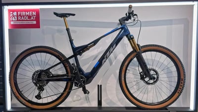 Ein blaues KTM E-Mountainbike mit braunen Reifen und goldenen Dämpfern. Ein blaues KTM E-Mountainbike mit braunen Reifen und goldenen Dämpfern.