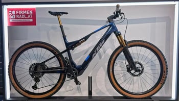 Ein blaues KTM E-Mountainbike mit braunen Reifen und goldenen Dämpfern.