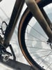 Detail des Rahmens und Rades eines Specialized Fahrrads mit braunen Reifenflanken.