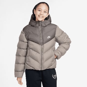 Mädchen in einer Daunenjacke von Nike mit Kapuze und Nike Hose.