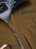 Detail einer Peak Performance Jacke mit Logo und Reißverschluss, hergestellt in Vietnam.
