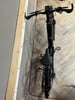 Ein schwarzes E-Bike steht auf einem Holzboden neben einer Wand.