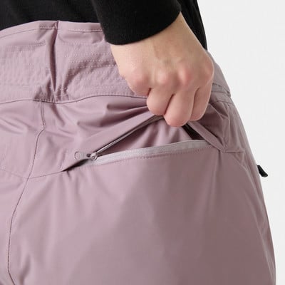 Detail einer Naht und eines Reißverschlusses an einer rosafarbenen Hose, in die eine Hand greift. Detail einer Naht und eines Reißverschlusses an einer rosafarbenen Hose, in die eine Hand greift.
