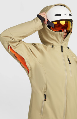 Eine beige Skijacke mit Kapuze und Reflektoren. Eine beige Skijacke mit Kapuze und Reflektoren.