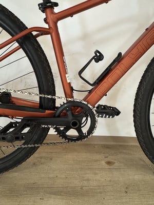 Detail eines Fahrrads mit orangefarbenem Rahmen und Kette. Detail eines Fahrrads mit orangefarbenem Rahmen und Kette.