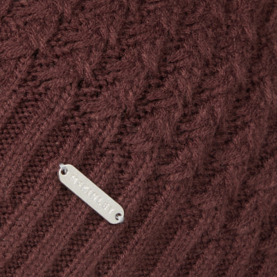 Braunes Strickmuster mit einem silbernen McKinley-Etikett. Braunes Strickmuster mit einem silbernen McKinley-Etikett.