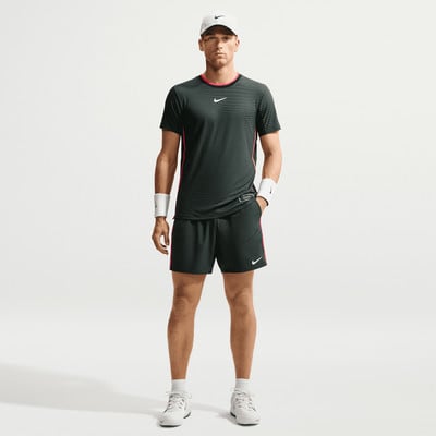 Ein Mann in Nike Tennisbekleidung steht vor weißem Hintergrund. Ein Mann in Nike Tennisbekleidung steht vor weißem Hintergrund.